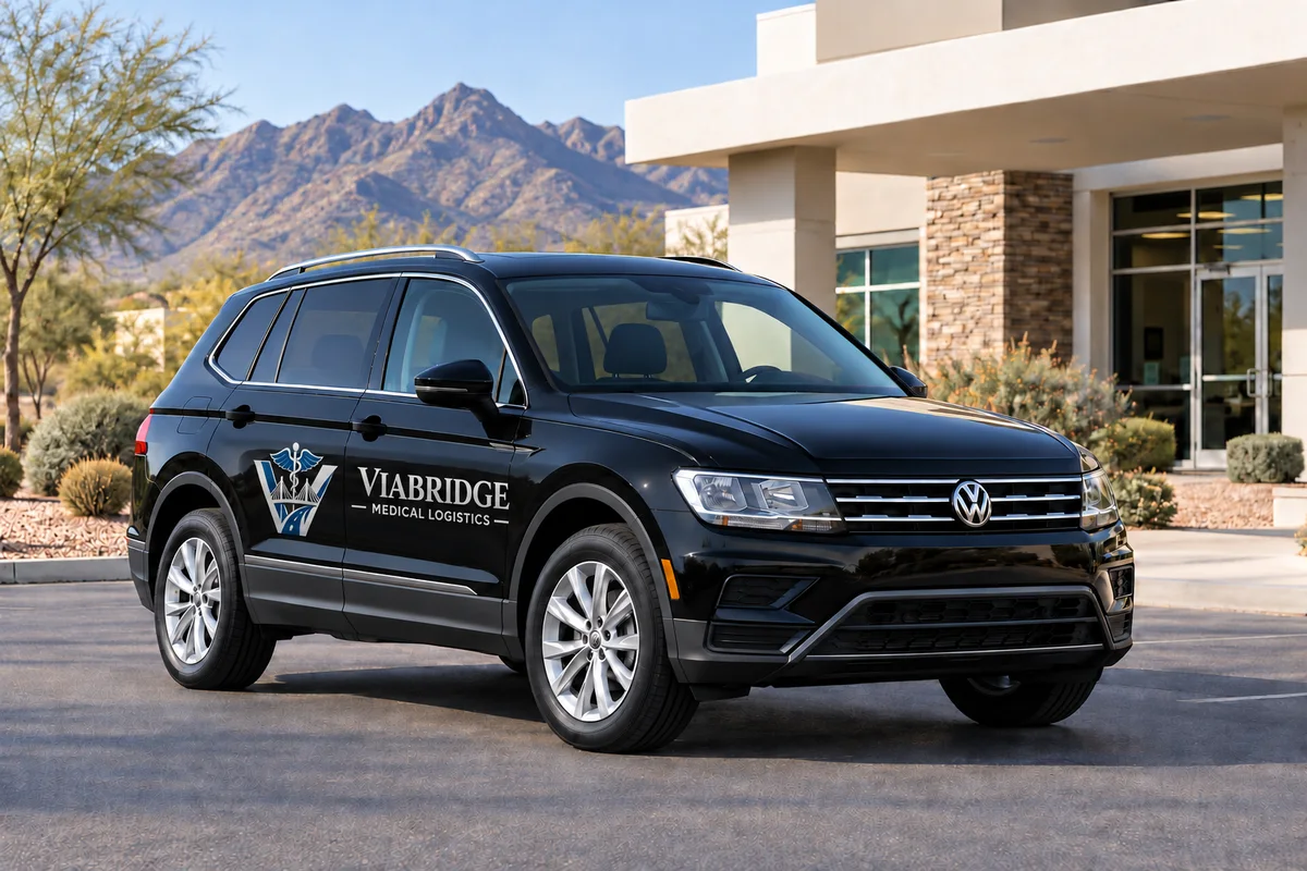 Illustration of a black Volkswagen Tiguan with silver Viabridge Medical Logistics door branding outside a Tucson-style medical office.